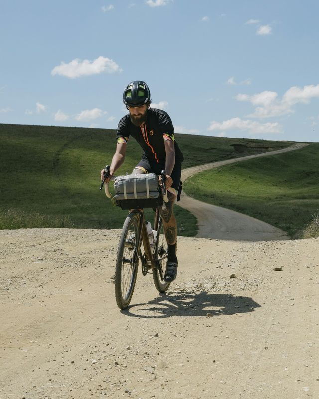 A rider on a gravel bike on a dusty trail