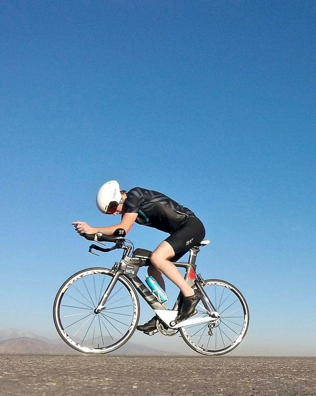 A road cyclist in an aero tuck on an open road